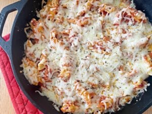 skillet of baked pasta topped with melted cheese