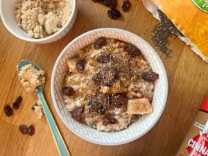 bowl of oatmeal topped with raisins, brown sugar, and chia seeds