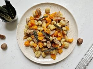 plate of chicken sausage, gnocchi, butternut squash, topped with fresh nutmeg and fried sage